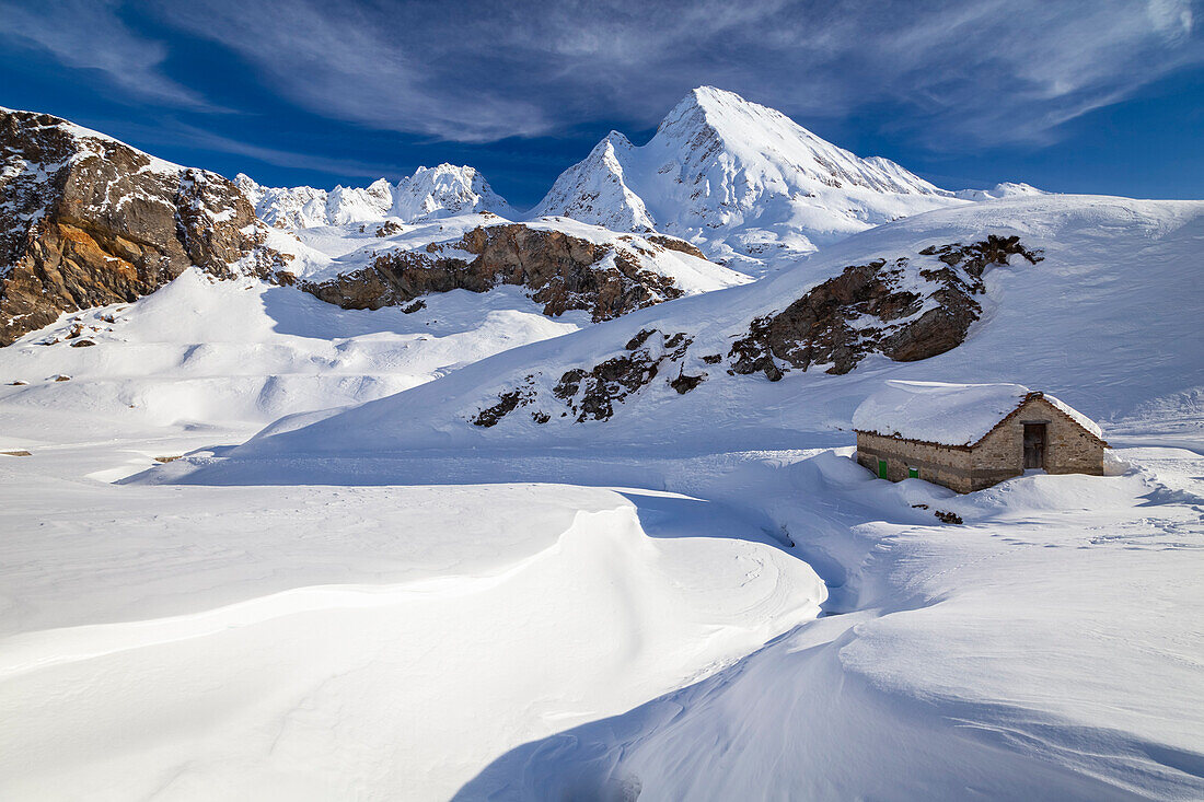 Blick auf eine Hütte in der Nähe der Maria-Luisa-Hütte und des Kastelhorns im Hochtal von Formazza im Winter. Riale, Formazza, Valle Formazza, Verbano Cusio Ossola, Piemont, Italien.