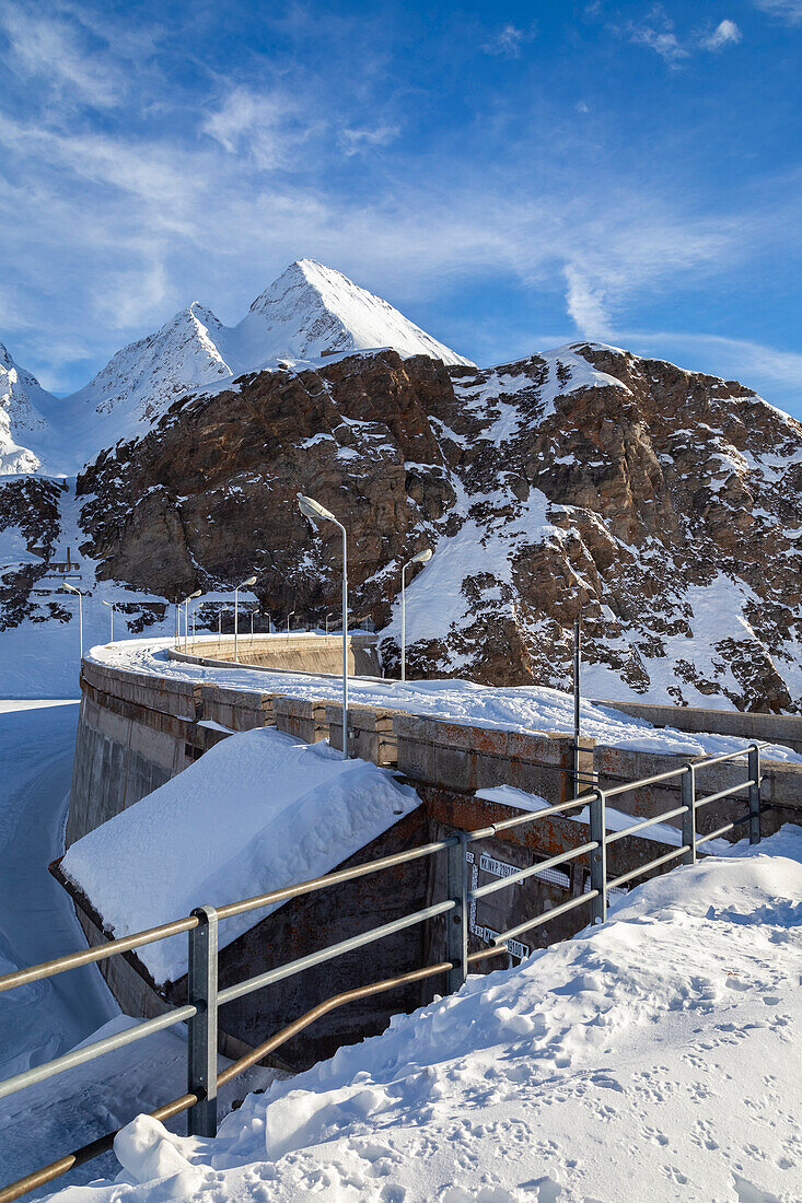 View of the dam of the Toggia Lake and Kastelhorn in the high Formazza Valley in winter. Riale, Formazza, Valle Formazza, Verbano Cusio Ossola, Piedmont, Italy.