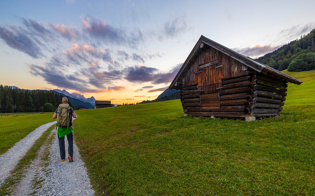 Ein Mann geht um den Geroldsee bei Sonnenuntergang im Sommer, Gerold, Krun, Landkreis, Garmisch Partenkirchen, Oberbayern, Deutschland, Deutschland, Westeuropa