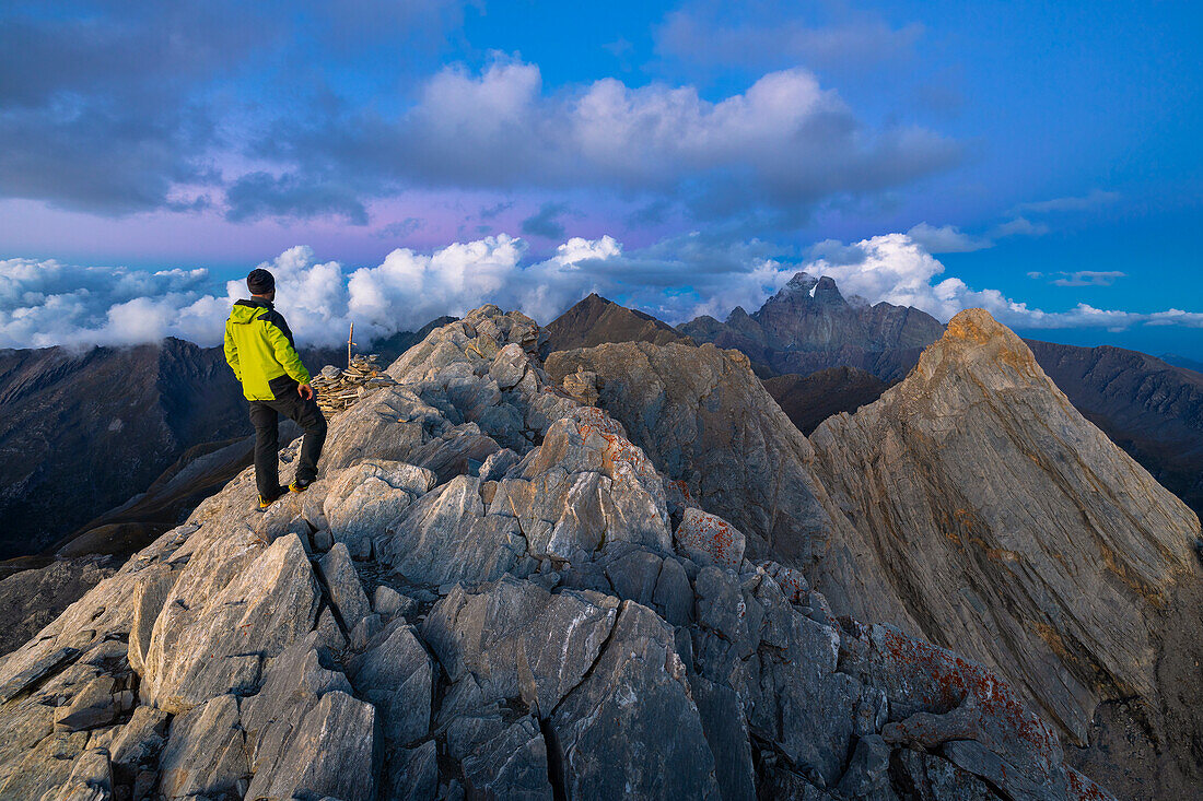 A trekker observes Monviso from Pain de Sucre during dusk at summer, Pain de Sucre, Col Agnel, Alpi Cozie, Alpi del Monviso, Cuneo, Piedmont, Italy, Southern Europe