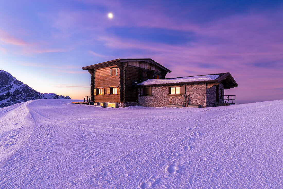 View of a colorful sunrise in front of the Rifugio Aquila in winter. Colere, Val di Scalve, Bergamo district, Lombardy, Italy, Southern Europe.