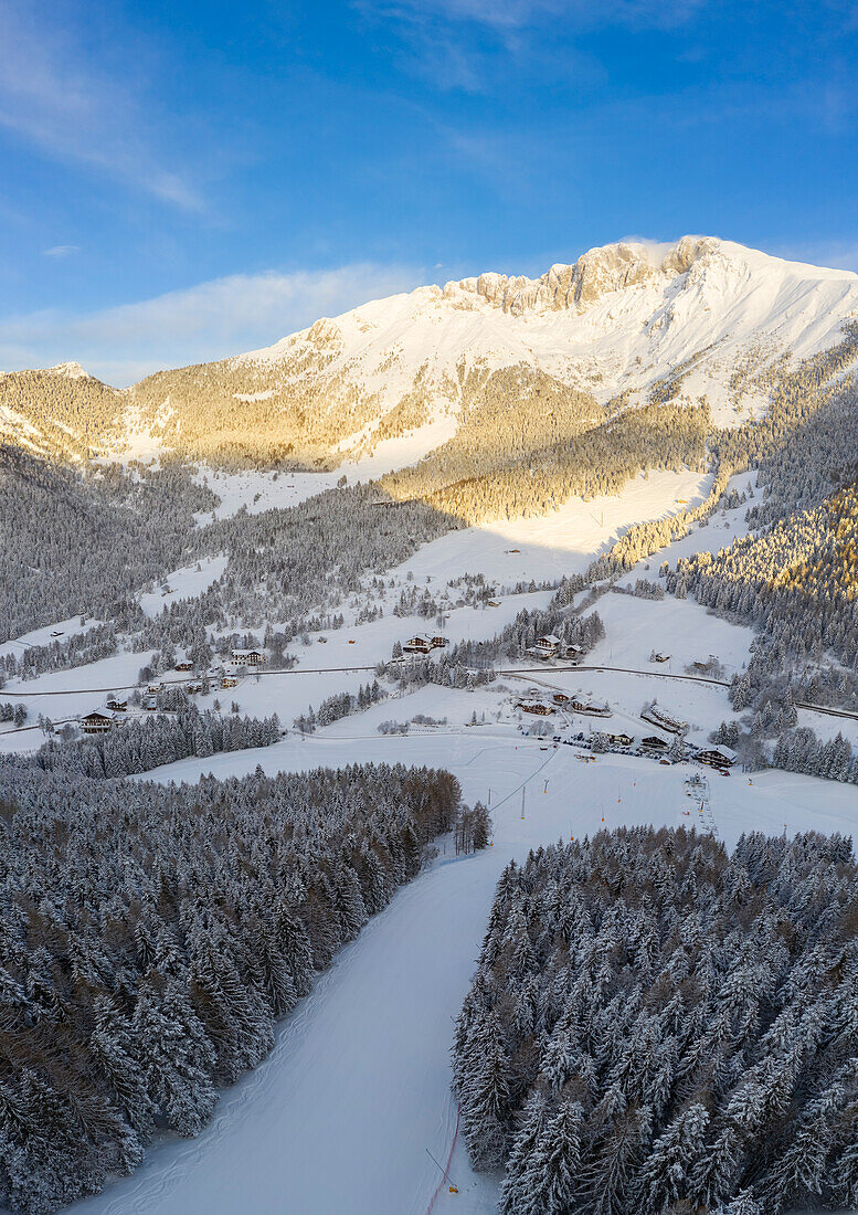 Aerial view of the ski slopes of the Presolana Pass and the Presolana massif after a winter sunrise. Presolana pass, Castione della Presolana, Seriana Valley, Bergamo province, Lombardy, Italy.