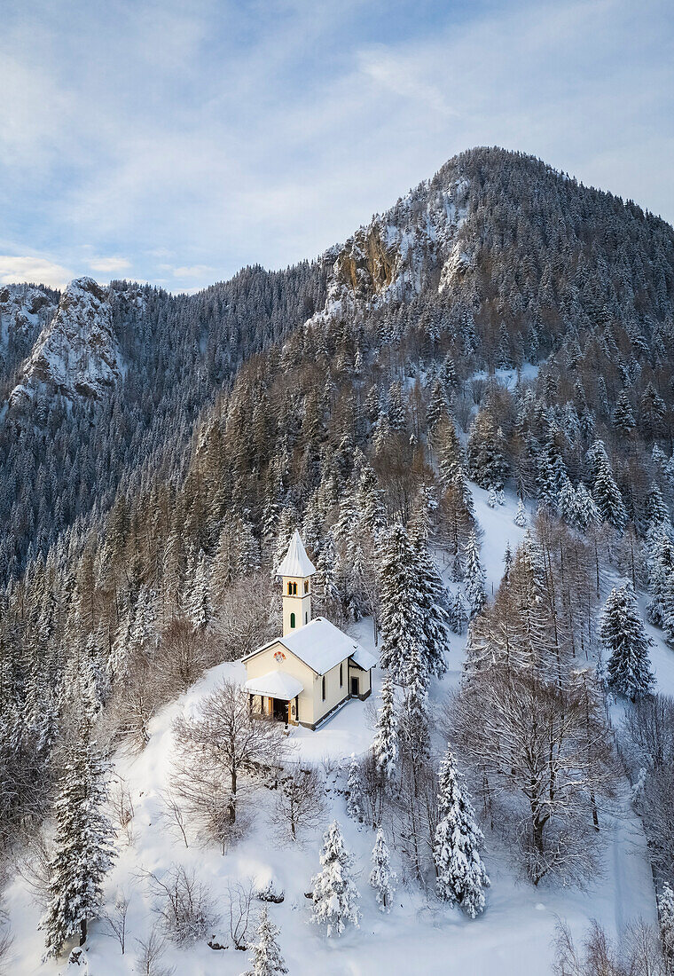 Aerial view of the Silvestri church and the Mount Scanapà during a winter sunrise. Presolana pass, Angolo Terme, Seriana Valley, Brescia province, Lombardy, Italy.