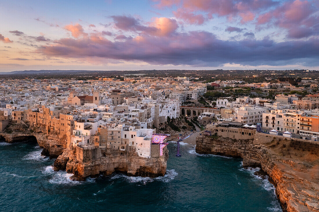 Luftaufnahme der überhängenden Häuser von Polignano a Mare bei Sonnenaufgang. Bezirk Bari, Apulien, Italien, Europa.