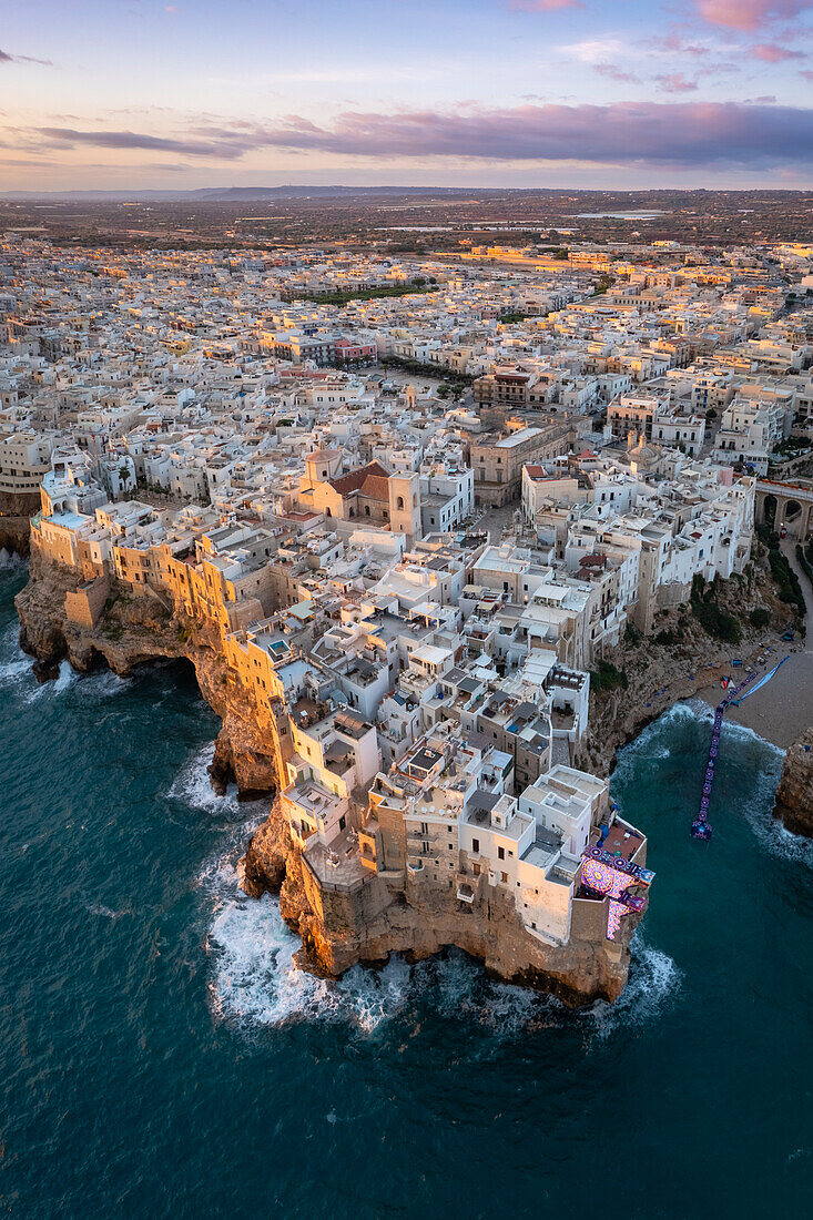 Luftaufnahme der überhängenden Häuser von Polignano a Mare bei Sonnenaufgang. Stadtviertel Bari, Apulien, Italien, Europa.