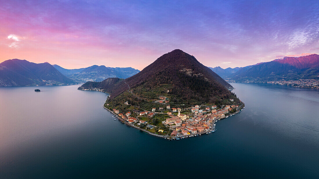 Luftaufnahme des Monte Isola und des Dorfes Peschiera Maraglio bei Sonnenuntergang am Iseosee. Peschiera Maraglio, Montisola, Provinz Brescia, Region Lombardei, Italien, Europa.