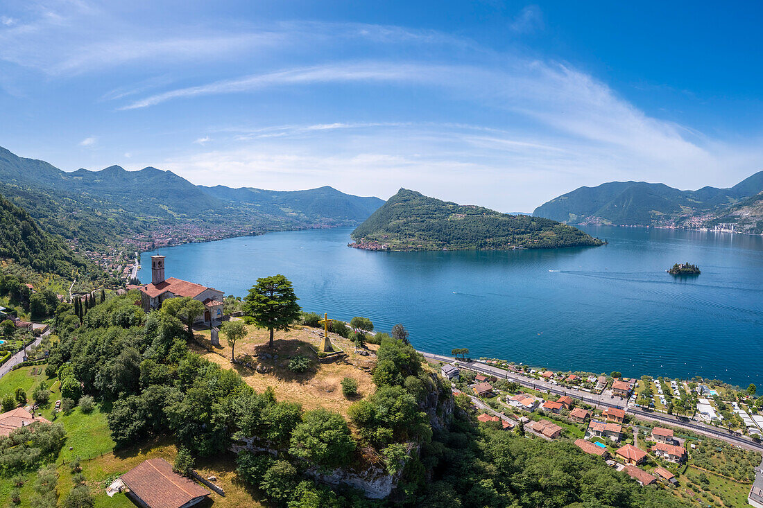 Aerial view of the Eremo di San Pietro church on a hill dominating Iseo lake, in front of Montisola. Marone, Brescia province, Lombardy, Italy, Europe.
