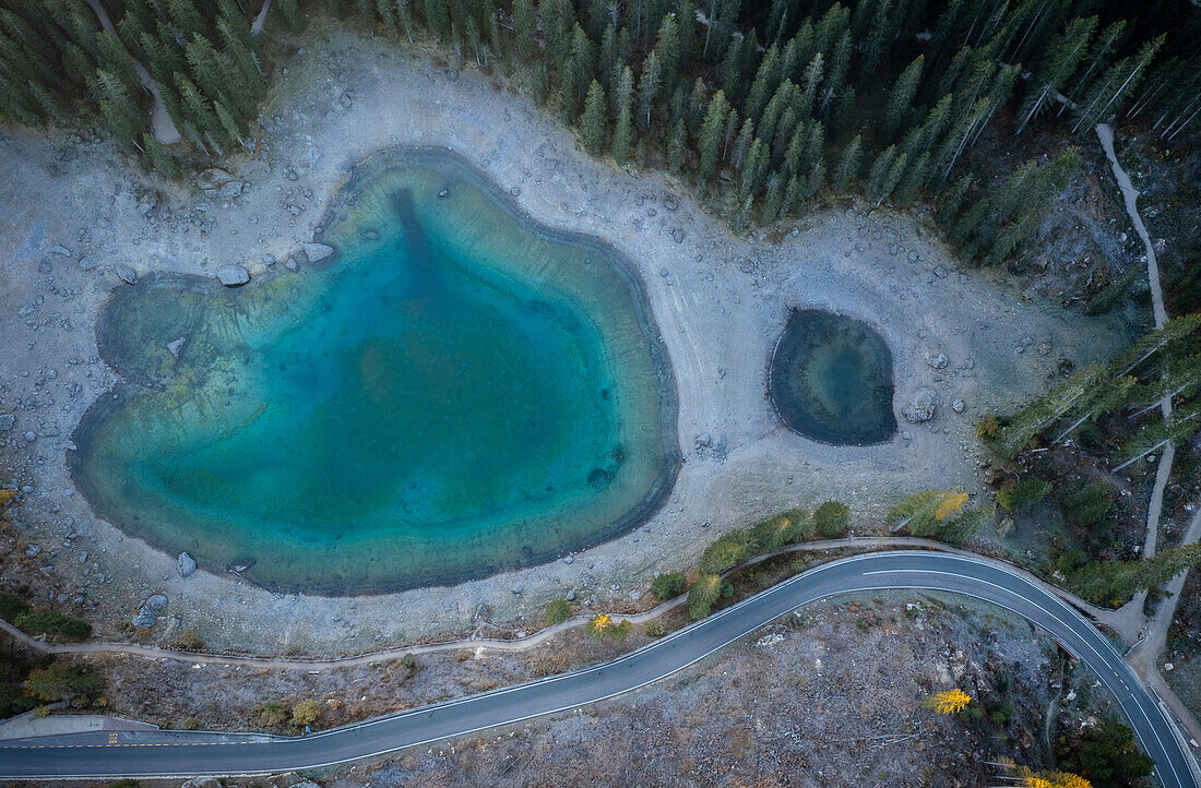 Aerial view of the Karersee lake in autumn at sunrise. Carezza, Dolomites, South Tyrol, Trentino Alto Adige, Italy.