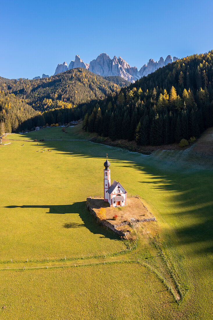 Aerial view of Ranui church with the Odle group in the background. Santa Magdalena Val di Funes, Funes Valley, Bolzano, South Tyrol, Trentino Alto Adige, Italy.
