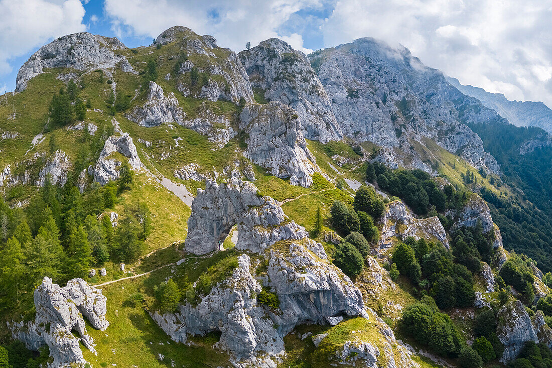 Aerial view of the natural rock arch called Porta di Prada with the Grigna Settentrionale mountain behind. Grigna Settentrionale, Mandello del Lario, Lombardy, Italy.