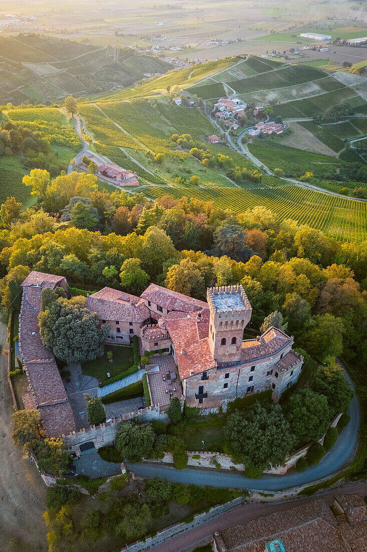 Luftaufnahme eines sommerlichen Sonnenuntergangs über dem Schloss Cigognola. Cigognola, Oltrepo Pavese, Bezirk Pavia, Lombardei, Italien.