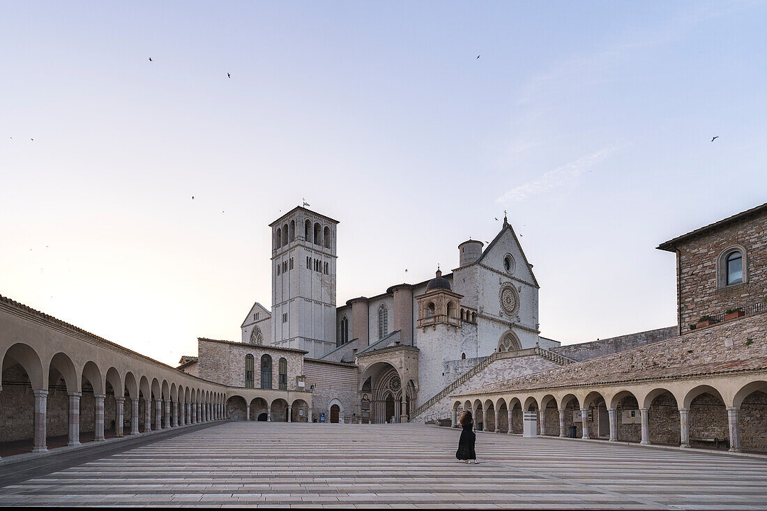 Ein junges Mädchen macht ein Foto von der Basilika des Heiligen Franziskus, Assisi, Umbrien, Italien, Europa