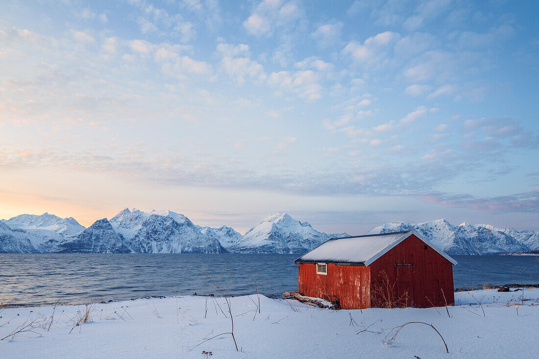 Europa, Norwegen, Troms: Rorbu mit Blick auf den Sonnenuntergang über den Lyngen-Alpen