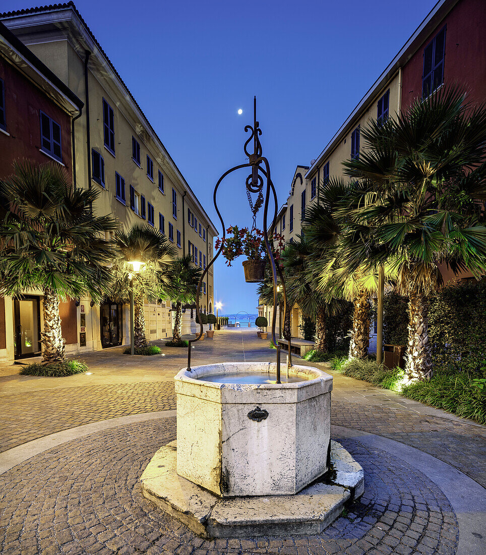 Castello Square in Sirmione, with medieval well in early moring illuminated,Lake of Garda, Sirmione, Brescia province, Lombardy, Italy, Europe, southern Europe.