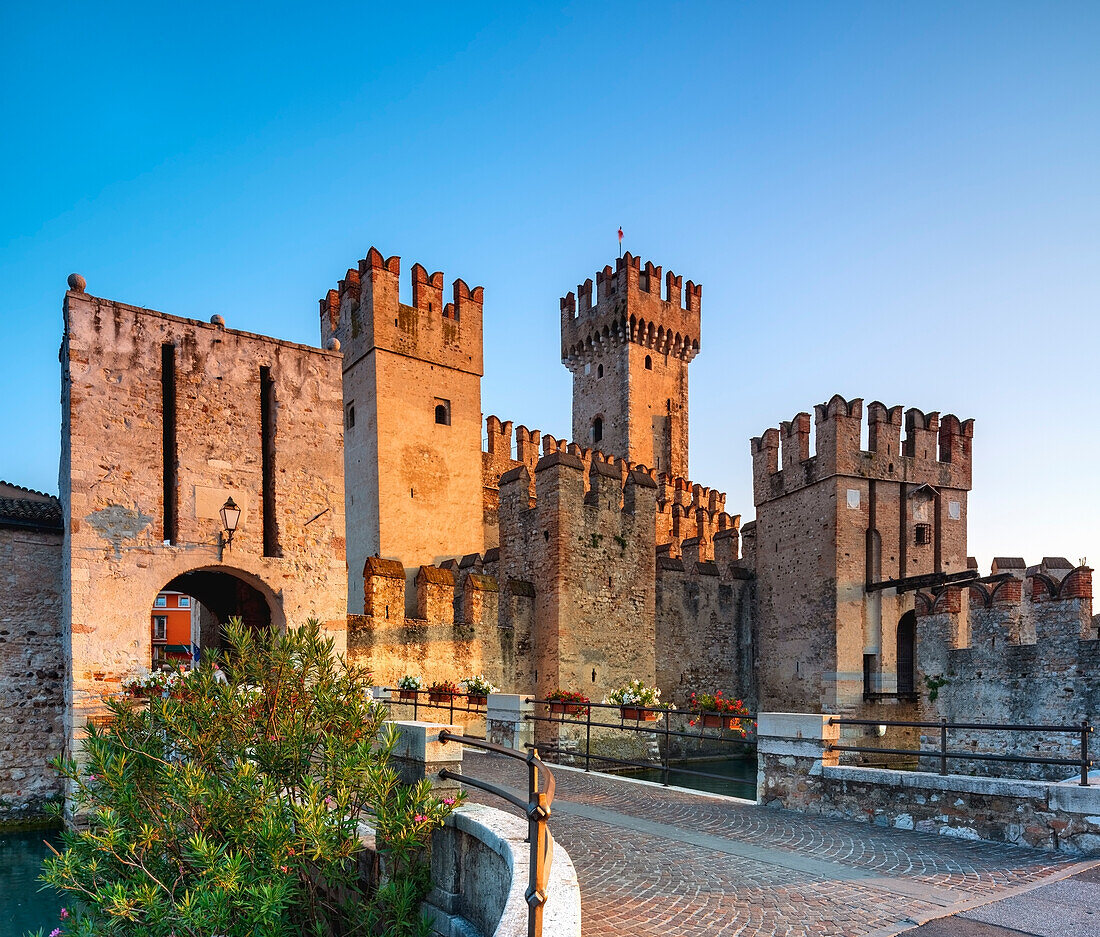 Scaliger Castle of Sirmione, entrance at sunrise with male tourist, Sirmione, Brescia province, Lake of Garda, Italy, Europe
