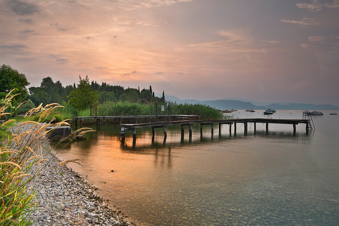 Beach in S.Felice of the Benaco, with old jetty and reeds during the sunrise; San Felice del Benaco, lake of Garda, province of Brescia, Lombardy, Italy, north Italy, Europe, south Europe