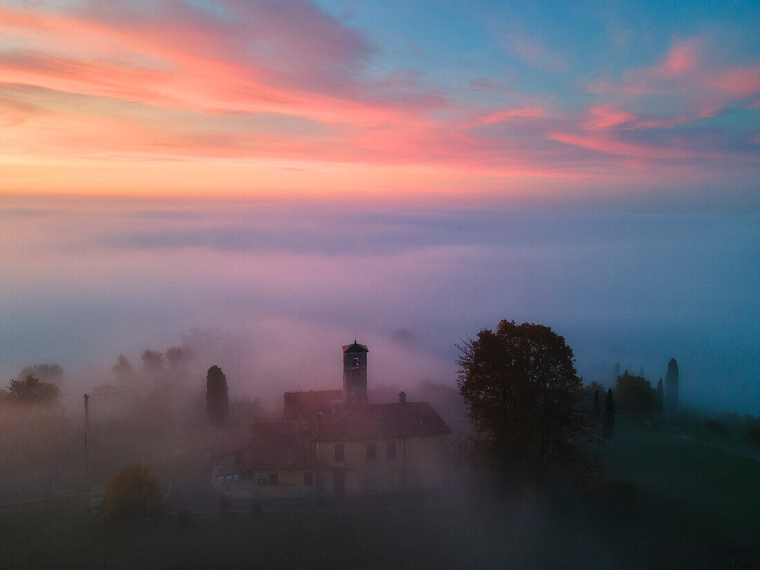 Kirche der Madonna di Santo Stefano über dem Nebel in der Morgendämmerung, Provinz Brescia, Lombardei, Italien, Europa.