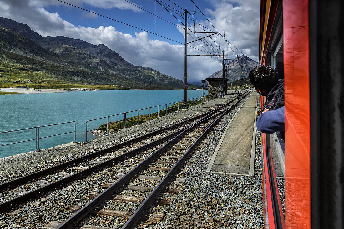 Bernina train tourist are watching panorma during the trip on the train, in Ospizio del Bernina with black and white lake Ospizio del Bernina, Canton Grigioni, Swizerland