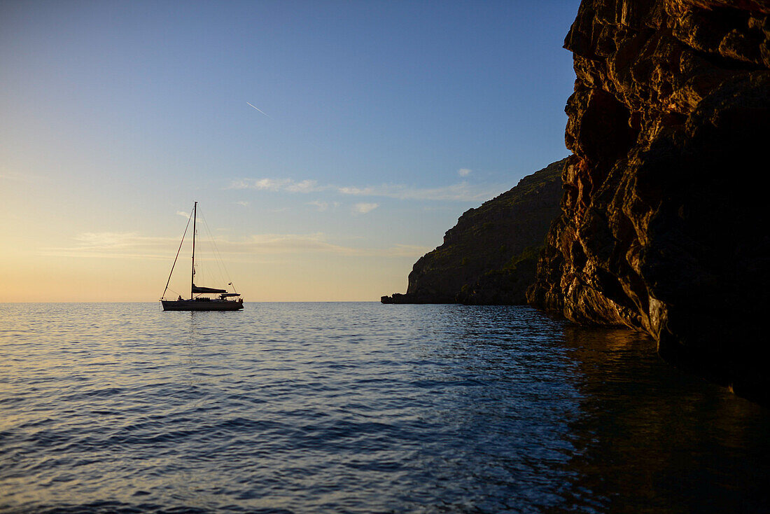 Segelboot bei Sonnenuntergang in Torrent de Pareis, Mallorca, Spanien