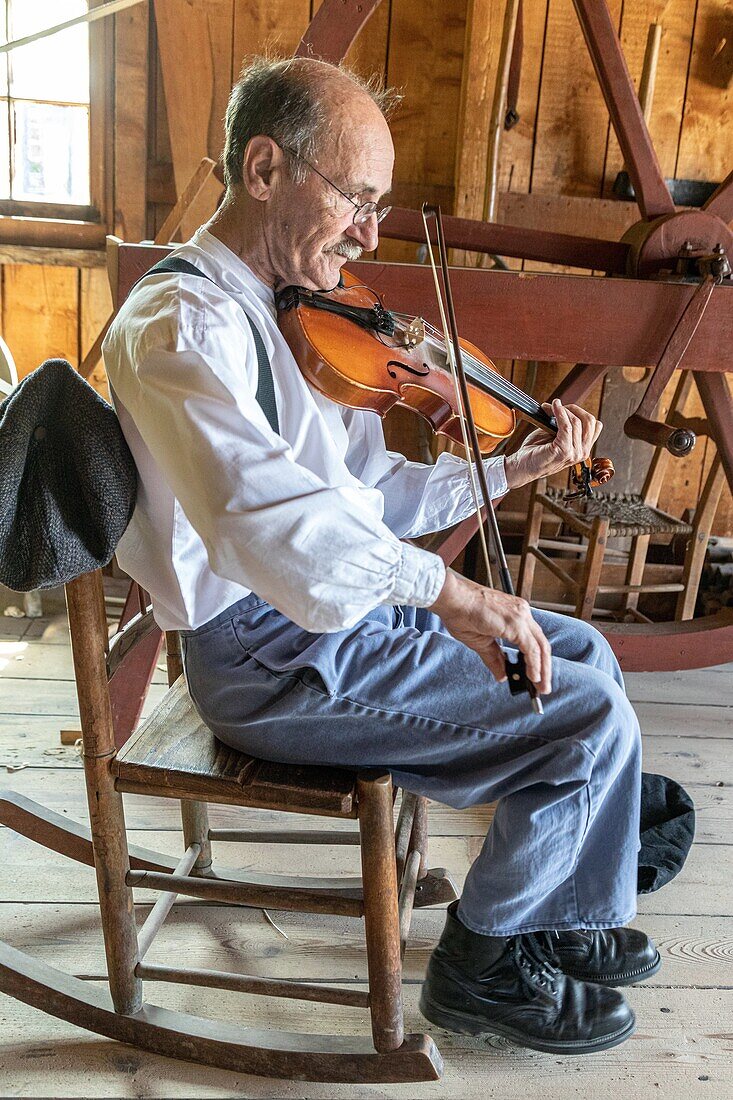 the acadian violinist in the woodwork shop; historic acadian village, bertrand, new brunswick, canada, north america
