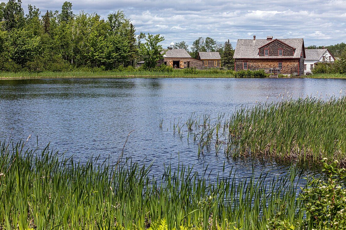 The lake and the flour mill built in 1895, historic acadian village, bertrand, new brunswick, canada, north america