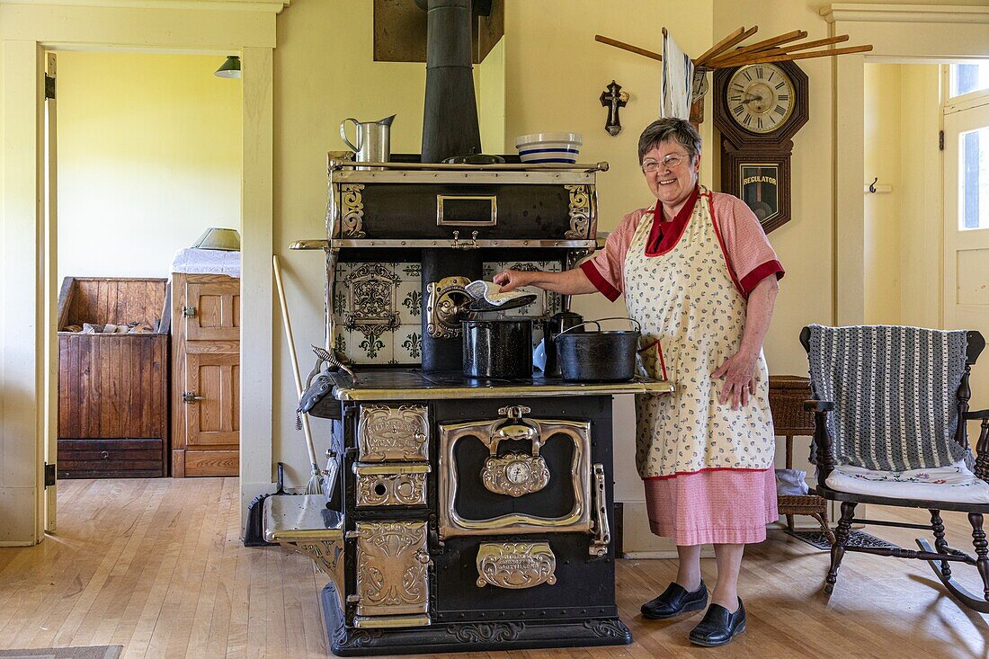 The cook at the stove in the turgeon house built in 1928, historic acadian village, bertrand, new brunswick, canada, north america