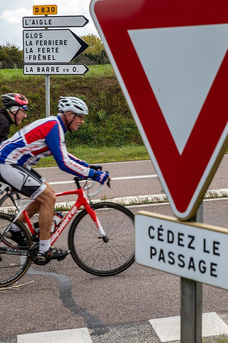 Radfahrer auf der Departementstraße d830, die die nächsten Dörfer anzeigt, Ausbeute, rugles, eure, normandie, frankreich