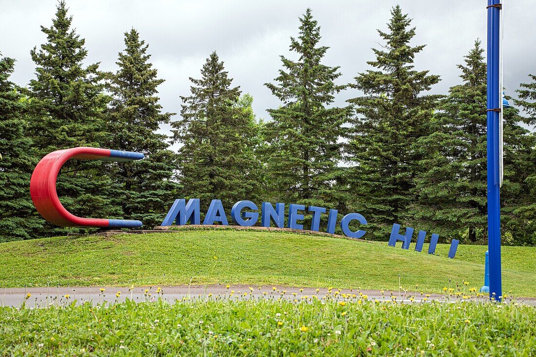 Magnetic hill, a gravity hill that creates an optical illusion that gives the impression of rolling uphill in reverse, moncton, new brunswick, canada, north america