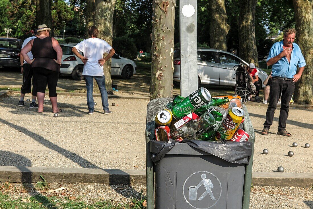 Street scene, garbage full of beer bottles, cigarette packs in front of the petanque field, blaye, gironde, france