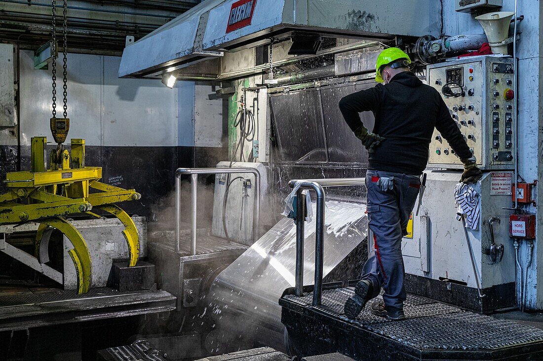 Flattening of the metal, spool of aluminum sheets with the worker in front of his calender, eurofoil factory, company specializing in aluminum metallurgy, rugles, eure, normandy, france