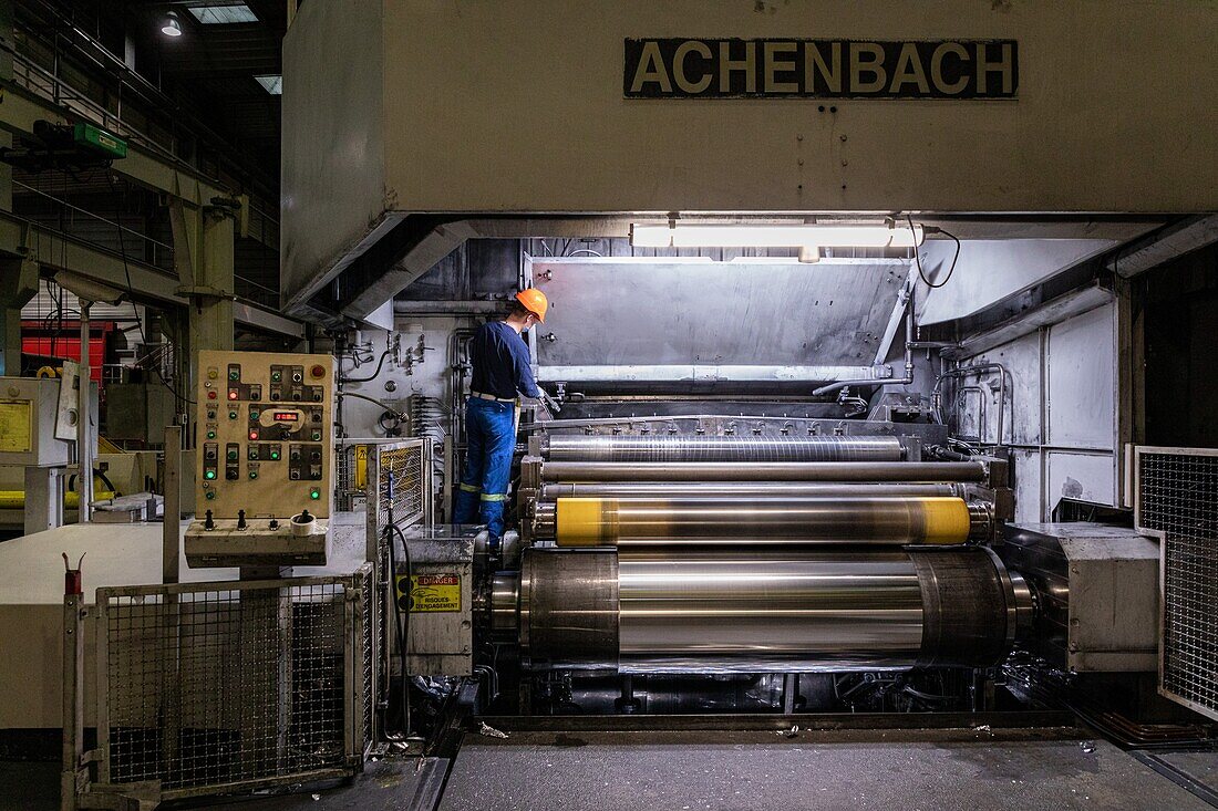 Flattening of the metal, spool of aluminum sheets with the worker in front of his calender, eurofoil factory, company specializing in aluminum metallurgy, rugles, eure, normandy, france