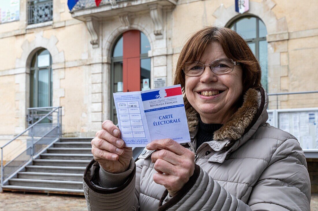 Bewohnerin, die mit ihrer Wahlkarte in der Hand zur Wahl gegangen ist, Pflegeheim für Erwachsene mit leichten geistigen Behinderungen, residence du moulin de la risle, le moulin rouge, rugles, eure, normandie, frankreich