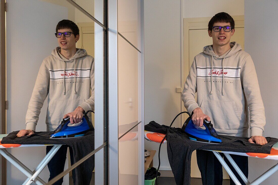 A totally autonomous resident doing his ironing, care home for adults with moderate mental disabilities, residence du moulin de la risle, rugles, eure, normandy, france