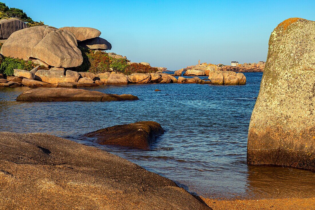 View of the ploumanach lighthouse from the pink granite boulders of saint-anne bay, renote island point, tregastel, pink granite coast, cotes-d’armor, brittany, france