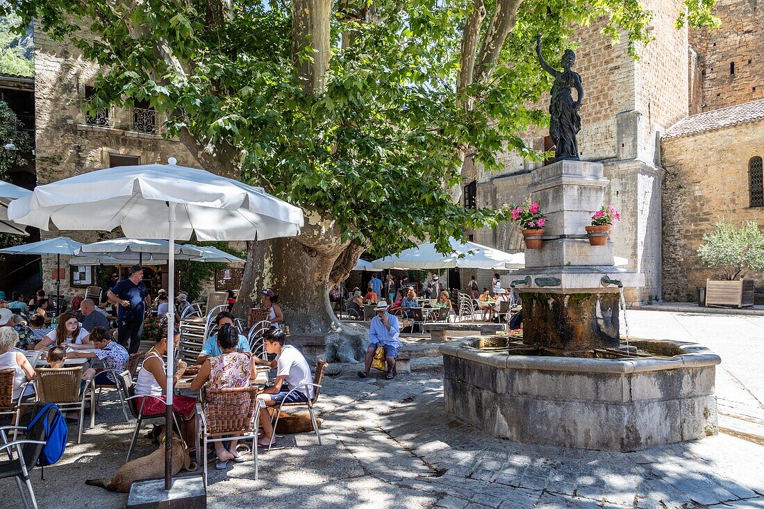 Restaurant terraces by the fountain beneath the remarkable sycamore, saint-guilhem-le-desert, classed as one of the most beautiful villages of france, herault, occitanie, france