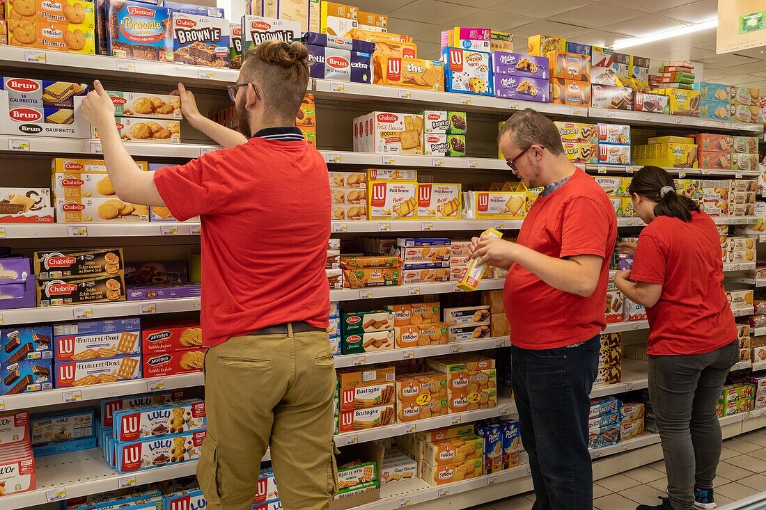 Stocking the shelves in a supermarket, workers with the esat les ateliers du coudray, adapei27, bernay, eure, normandy, france