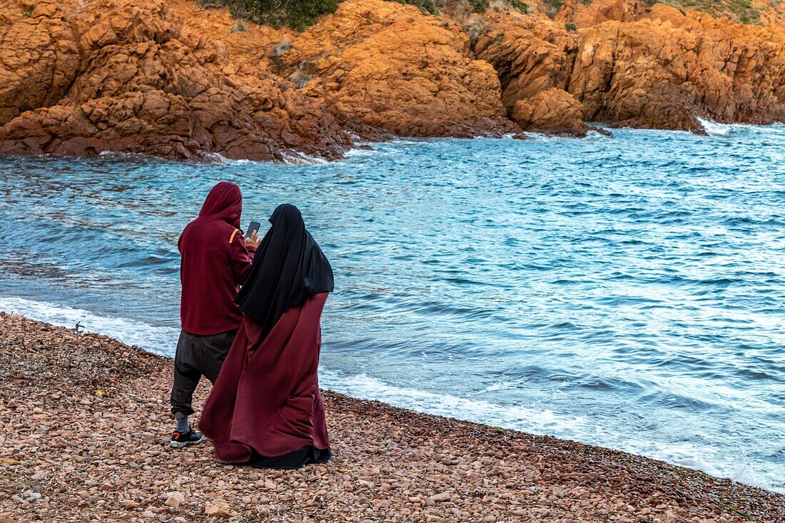 Muslimisches Paar in der Calanque du petit caneiret, die roten Felsen des Massivs de l'esterel, saint-raphael, var, Frankreich