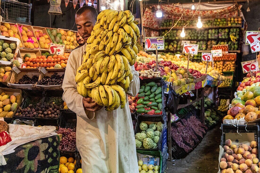 Verkäufer mit seinem Bananenstrauß, Obst- und Gemüsestand, El Dahar-Markt, beliebtes Viertel in der Altstadt, Hurghada, Ägypten, Afrika