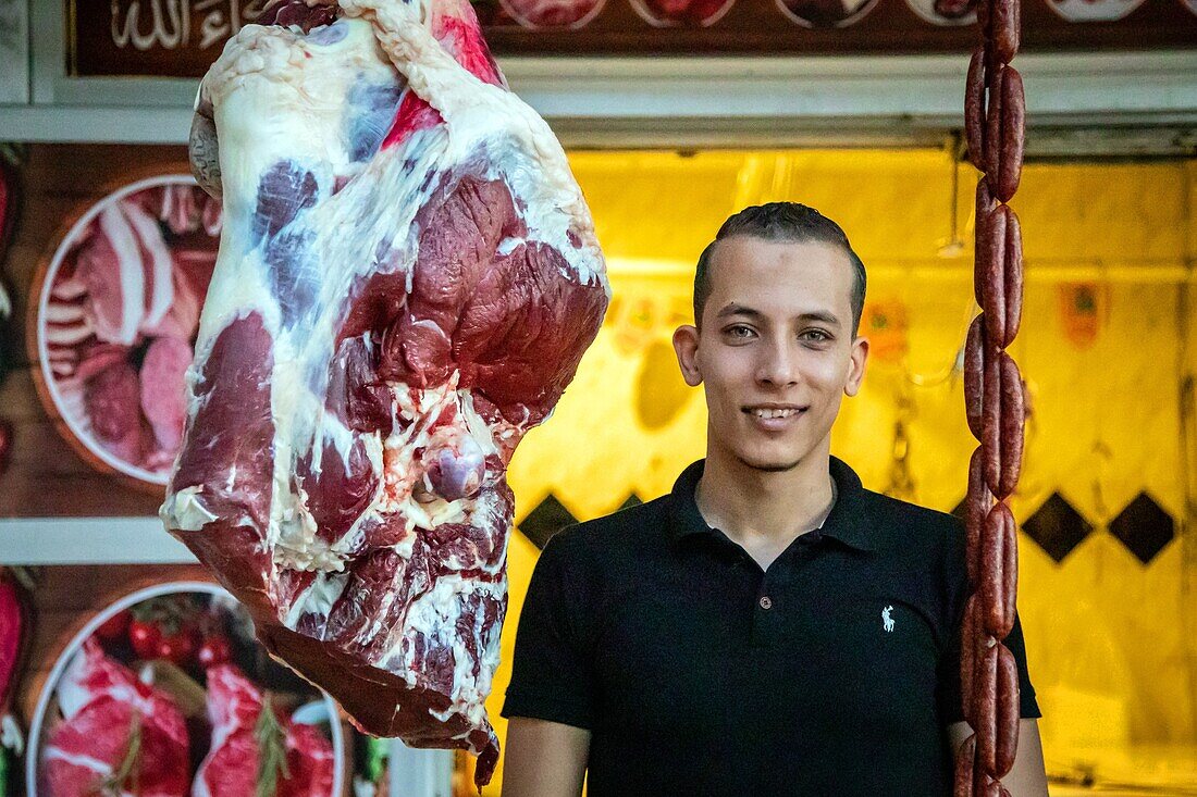 Young butcher in front of his meat, el dahar market, popular quarter in the old city, hurghada, egypt, africa