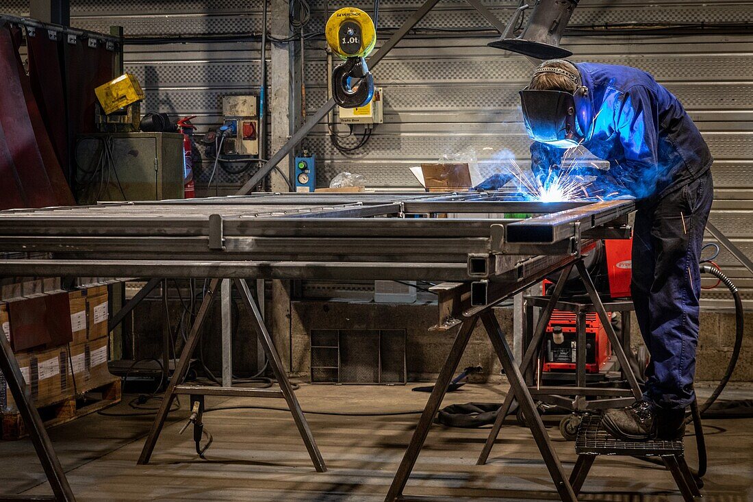 Schweißplatz, Schweißer bei der Montage von Metallteilen in seinem Werk, l'aigle, orne, normandie, frankreich