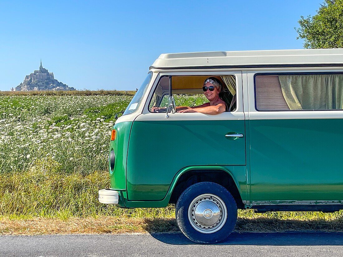 Frau am Steuer eines Kombi-Volkswagens bei einer Fahrt durch die Landschaft, mont-saint-michel, manche, normandie, frankreich