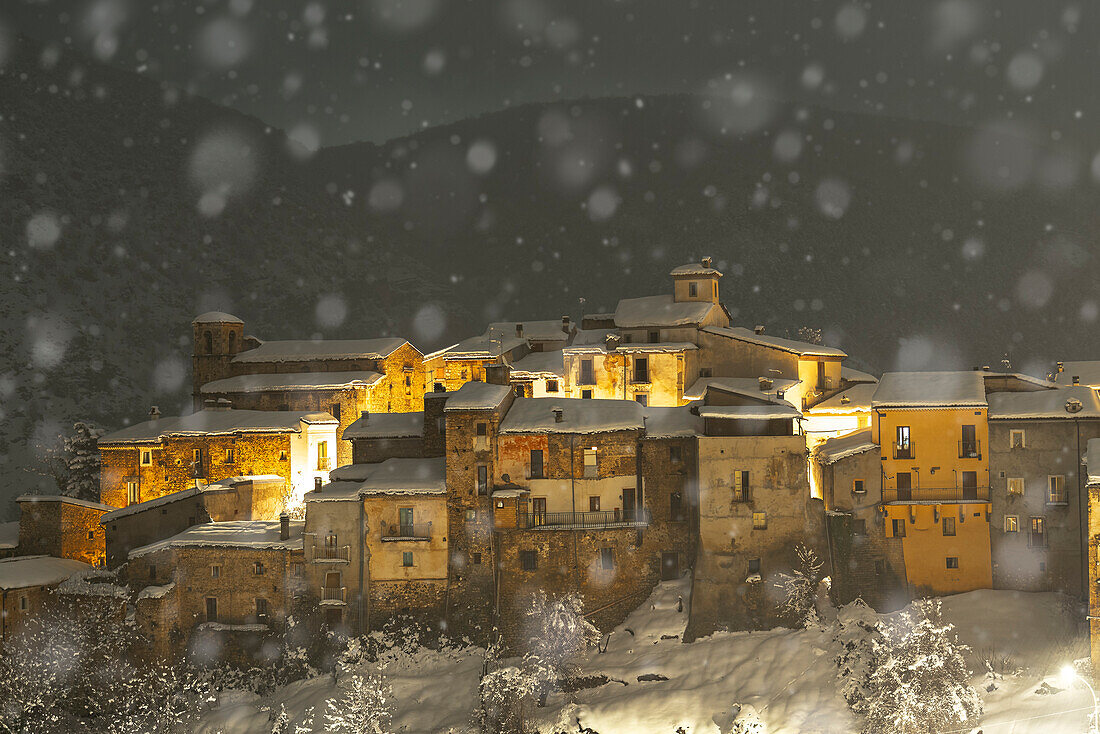 Night view of the illuminated village of Cansano under heavy snowfall, L’Aquila province, Abruzzo, Italy