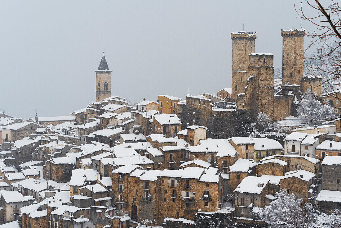 Das mittelalterliche Dorf Pacentro bei starkem Schneefall mit dem Schloss, der Turmglocke und dem schneebedeckten Haus, Gemeinde Pacentro, Nationalpark Maiella, Provinz L'aquila, Abruzzen, Italien
