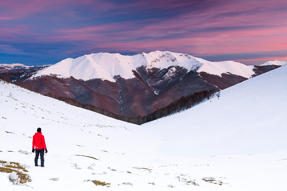 Mann bewundert den schneebedeckten Berg Viglio in der Abenddämmerung, Apennin, Regionalpark Simbruini, Provinz Frosinone, Latium, Italien