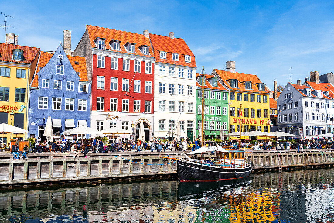 Blick auf die bunten Gebäude und ein altes Schiff entlang des Nyhavn-Kanals mit Spiegelung im Wasser, Kopenhagen, Hovedstaden Dänemark, Europa