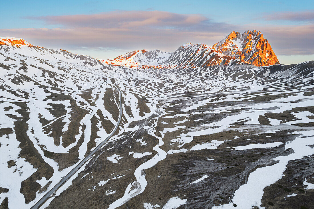 Aerial view of the sunrise on the peak of Gran Sasso and the Campo Imperatore plateau during the spring thaw, Gran Sasso and Monti della Laga national park, L’Aquila province, Abruzzo, Italy