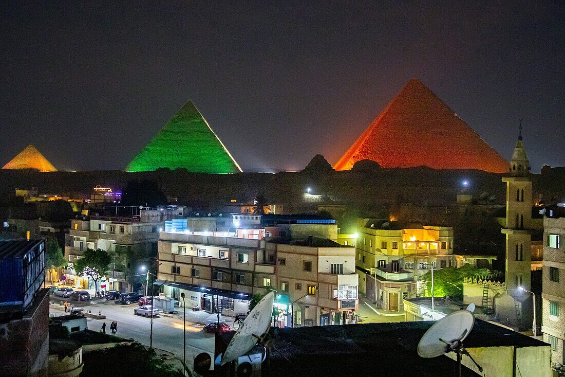 Hotelterrasse und beleuchtetes Stadtviertel während der Ton- und Lichtshow an den Pyramiden von Gizeh, Kairo, Ägypten, Afrika