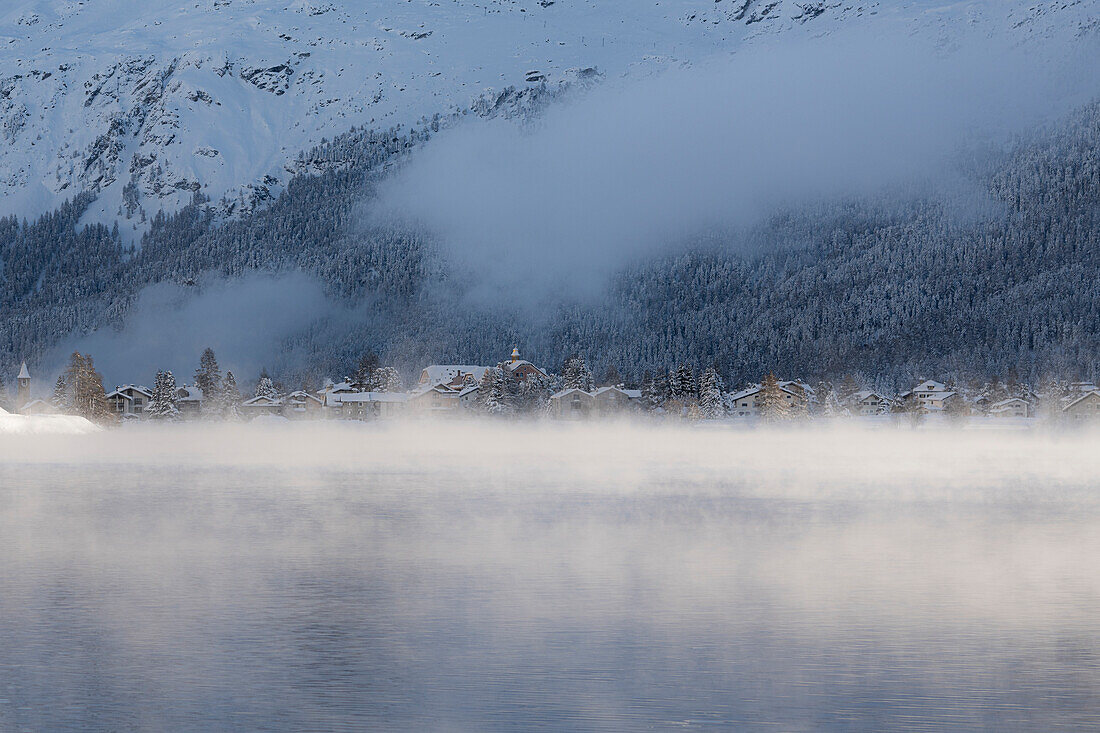 Nebel über dem Silsersee um das verschneite Dorf Sils Maria, Kanton Graubünden, Engadin, Schweiz