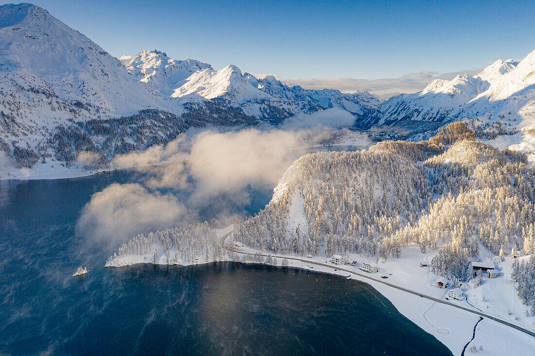 Straße im verschneiten Winterwald am Ufer des Silsersees und Plaun Da Lej, Luftaufnahme, Engadin, Schweiz
