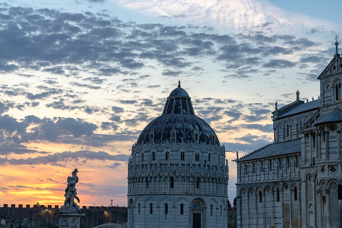 Cloudy sky at sunset over the Baptistery and Duomo or Cathedral, Piazza dei Miracoli, Pisa, Tuscany, Italy